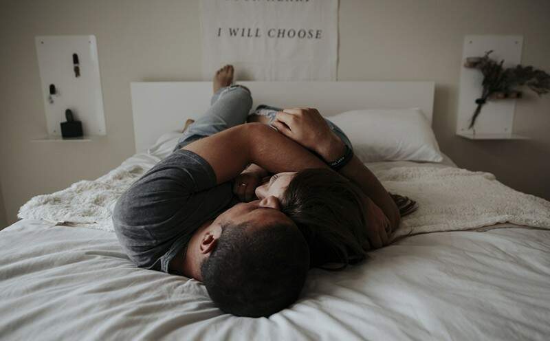 sexologia homem e mulher deitados na cama abraçados